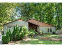 Well-maintained single story house featuring a green lawn and complemented by mature trees at 7357 Elwood Dr, Charlotte, NC 28227
