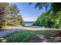 Scenic view of the lake with mature trees lining the quiet street, offering a tranquil and picturesque setting at 7733 Skyline Dr, Sherrills Ford, NC 28673