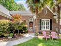 Welcoming entryway with decorative landscaping and charming pink chairs on the front lawn at 8128 Sealey Ct, Charlotte, NC 28277