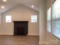 Well-lit living room featuring a decorative fireplace and large windows with blinds at 913 Winchester Ave, Monroe, NC 28110