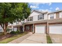 Charming two-story townhome with brick and white siding, featuring a one-car garage and inviting front entrance at 104 Clydesdale Ct, Matthews, NC 28104