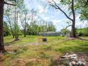 Expansive backyard showcasing mature trees, greenery, and a rock feature, creating a private outdoor space at 105 Strickland Ln, Bessemer City, NC 28016