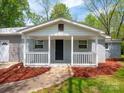 Inviting front porch with white railing and a dark-colored front door creates a welcoming entrance to this home at 105 Strickland Ln, Bessemer City, NC 28016