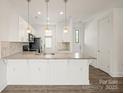 Bright kitchen with white cabinets, pendant lighting, and a spacious granite countertop island at 1101 W 1St St # 408, Charlotte, NC 28202