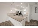 Modern kitchen featuring white cabinets, stainless steel appliances, and a large granite island at 1101 W 1St St # 408, Charlotte, NC 28202