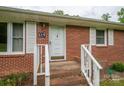 Close-up of the front door of a brick home with white trim and a welcoming entrance at 115 Patterson Rd, Kings Mountain, NC 28086
