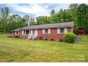 Classic brick home featuring white shutters, a green lawn, and mature trees in a tranquil setting at 115 Patterson Rd, Kings Mountain, NC 28086