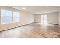 Bright living room featuring hardwood floors, large windows, and a sliding glass door to the backyard at 118 Dorian Pl, Troutman, NC 28166