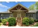 Inviting front porch with stone facade, wood columns and a peaked roof at 146 Paradise Peninsula Rd, Mooresville, NC 28117