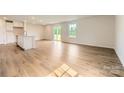 Bright, open-concept living room featuring hardwood floors, large windows, and sliding doors to backyard at 151 Astor St, Troutman, NC 28166