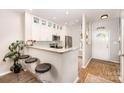 Well-designed kitchen boasts stainless steel appliances, white cabinets, bar seating and wood flooring at 15318 Coventry Court Ln, Charlotte, NC 28277