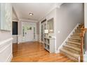 Bright foyer with hardwood floors, staircase, and wainscoting offering a welcoming entrance to the home at 15807 Foreleigh Rd, Huntersville, NC 28078