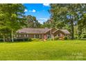 Traditional brick home featuring a well-manicured lawn and a patriotic flagpole at 1760 Jacobs Way, Sherrills Ford, NC 28673