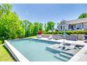 Beautiful backyard pool area with stylish lounge chairs, lush landscaping, and a view of the well-maintained home exterior at 1780 Sierra Rd, York, SC 29745