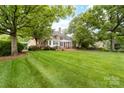 Expansive backyard featuring a lush green lawn, mature trees, a patio and a pergola, perfect for outdoor living at 18920 Peninsula Club Dr, Cornelius, NC 28031