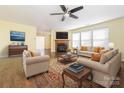 Spacious living room featuring a fireplace, ceiling fan, and lots of natural light at 2017 Beckwith Ln, Waxhaw, NC 28173