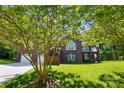 Beautiful brick home with a well-maintained lawn and lush greenery creating a private and inviting atmosphere at 221 Grayrock Dr, Statesville, NC 28677