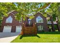 Stunning brick home featuring a manicured lawn, two-car garage, and welcoming entrance with beautiful landscaping at 221 Grayrock Dr, Statesville, NC 28677