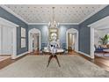 Grand foyer featuring patterned wallpaper, hardwood floors, arched doorways, and a stunning chandelier at 2322 Hopedale Ave, Charlotte, NC 28207