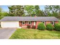 Charming brick ranch home featuring an attached garage, well-manicured lawn, and mature landscaping at 326 N Greenbriar Rd, Statesville, NC 28625