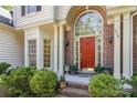 The front entrance features a striking red door framed by brick columns and lush landscaping at 3710 Cheleys Ridge Ln, Charlotte, NC 28270