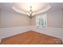 Empty dining room with wood flooring, a chandelier, and wainscotting at 427 Pinnacle Ln, Huntersville, NC 28078