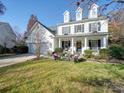 Charming two-story home with a well-manicured lawn, seating, and a welcoming front porch at 5076 Timber Falls Dr, Indian Land, SC 29707