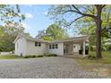 View of a backyard with white brick home, carport and gravel area at 528 W Park Dr, Monroe, NC 28112