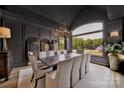 Sophisticated dining room boasting elegant chandelier, dark walls, and a large window with scenic view at 611 Wisteria Vines Trl, Fort Mill, SC 29708
