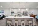 The kitchen is shown with white cabinets, stainless steel appliances, pendant lighting, and an island with seating at 6242 Ashton Park Dr, Denver, NC 28037
