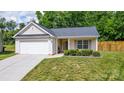 Charming single-story home with a well-maintained lawn, garage, and inviting front porch at 6808 Squirrels Foot Ct, Charlotte, NC 28217
