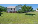 Backyard of house with manicured lawn, AC unit and mature shade trees at 727 Skinner Rd, Shelby, NC 28152