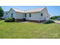 Rear view of house with well-maintained lawn, back door and garage entrance at 727 Skinner Rd, Shelby, NC 28152