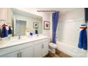 Bright bathroom featuring double sinks, white cabinets, a tub, and blue and white accents at 1007 20Th Avenue Se Loop, Hickory, NC 28602