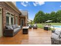 Outdoor deck featuring comfortable seating, overlooking manicured lawn and inground pool at 105 Walnut Hill Ct, Mooresville, NC 28115