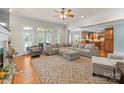 Open-concept living room featuring hardwood floors, a large sectional sofa, and backyard access at 105 Walnut Hill Ct, Mooresville, NC 28115