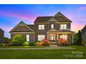 Twilight image of a charming two-story brick home with manicured lawn at 10517 Sable Cap Rd, Mint Hill, NC 28227
