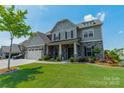 Charming exterior showcasing stone accents, a manicured lawn, and a three-car garage at 1107 Castle Rd, Indian Land, SC 29707