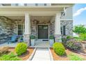 Inviting covered front porch with stone columns and decorative landscaping at 1107 Castle Rd, Indian Land, SC 29707