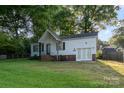 A charming single-story home featuring white siding, a brick foundation, and a lush green lawn at 1108 Old Dallas Hwy, Dallas, NC 28034