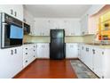 Functional kitchen with white cabinets, black appliances, and laminate wood flooring at 1108 Old Dallas Hwy, Dallas, NC 28034