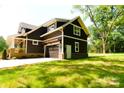 A dark colored two-story home features a two car garage, backyard and lawn at 116 S Broad St, Waxhaw, NC 28173