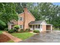 Brick home featuring an attached garage, mature landscaping, and a charming walkway at 1209 Alfred St, Charlotte, NC 28211