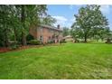 Spacious front yard of a brick home, showcasing beautiful landscaping and mature trees at 1209 Alfred St, Charlotte, NC 28211