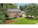 Aerial view of the classic brick home with lush green lawn and mature trees on a large lot at 1209 Alfred St, Charlotte, NC 28211