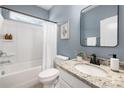 Cozy bathroom featuring granite countertops, a framed mirror, and a shower-tub combination, designed for relaxation and comfort at 14210 Asbury Park Rd, Huntersville, NC 28078