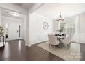 Elegant dining room featuring wainscoting, chandelier, table for six, and hardwood floors at 14210 Asbury Park Rd, Huntersville, NC 28078
