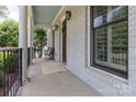 Inviting front porch showcasing brick accents, a light blue ceiling, and ample space for outdoor seating and decor at 1517 Waverly Ave, Charlotte, NC 28203