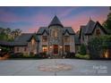Elegant stone home with tower, inviting entryway, and manicured landscaping at 172 Tennessee Cir, Mooresville, NC 28117