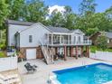 Beautiful backyard featuring a large swimming pool, covered patio, and stairs to the upper deck at 208 Wellington Dr, Lincolnton, NC 28092